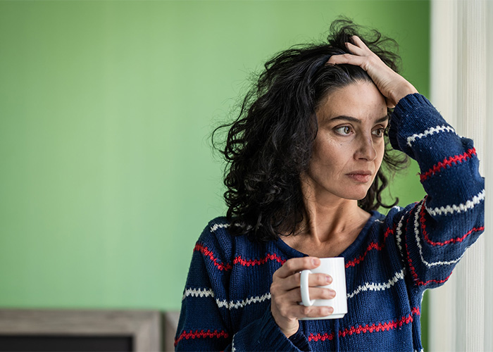 A stressed woman holding a coffee mug