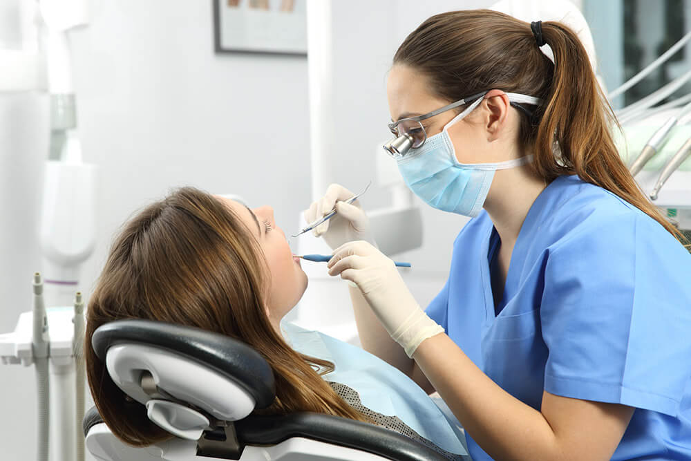 dentist cleaning patients teeth